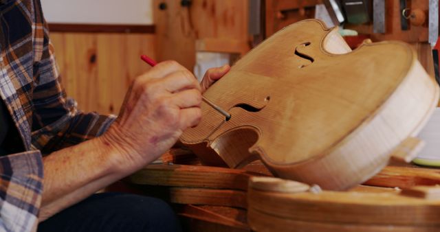 Depicts a craftsman working on a wooden violin in a workshop, highlighting the intricate details and handcrafting involved in the process. Ideal for use in materials related to musical instrument making, traditional crafts, or showcasing detailed craftsmanship. Suitable for educational resources, artists' portfolios, or as part of advertisements for workshops and artistic communities.