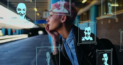 Caucasian woman with pink hair and digital interface at station