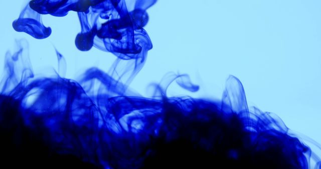 Abstract image featuring blue ink swirling and diffusing in water. The vivid colors and flowing shapes create an artistic and dynamic visual suitable for backgrounds, design projects, and posters related to creativity and art.