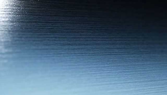 Brushed aluminum texture fine horizontal grain blue-gray gradient macro closeup