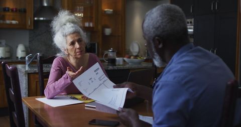Senior Couple Reviewing Finances Together at Kitchen Table