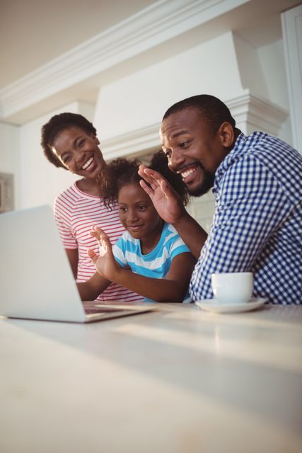 Happy family having a video call on laptop at home