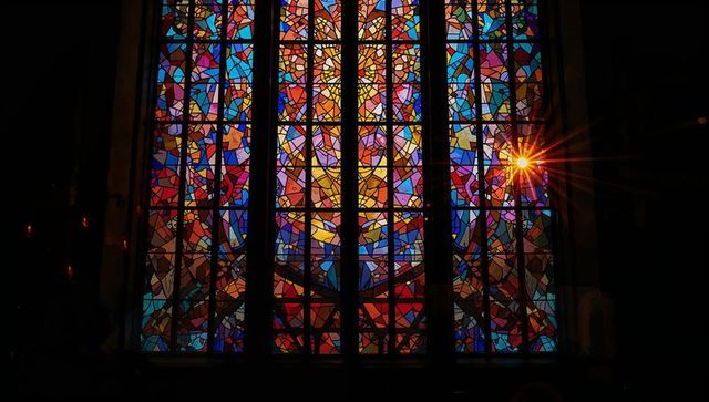 Vibrant stained glass with radiant sunburst in sanctuary