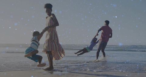Family Swinging Kids on Beach at Low Tide with Backlit Silhouettes and Ocean Horizon