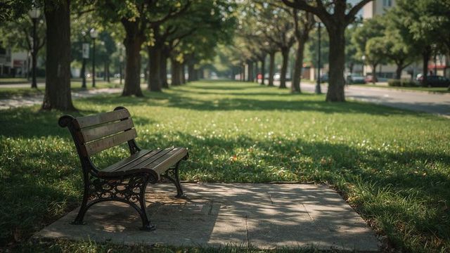 Serene park bench amidst tree-lined grassy median