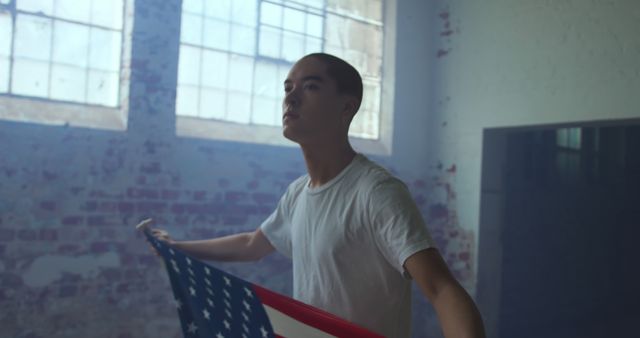 Young Man Holding American Flag in Abandoned Warehouse - Download Free Stock Images Pikwizard.com