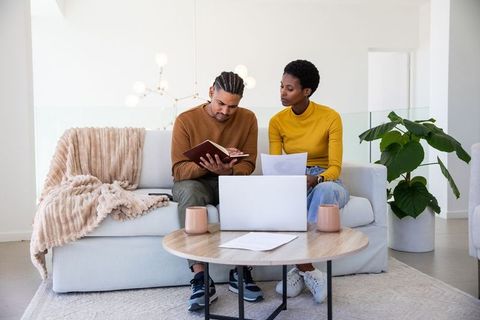 Diverse Couple Collaborating on Task at Cozy Home