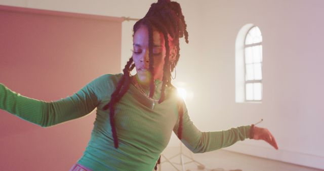 Professional african american female dancer dancing with lamp in background in dance studio. Activity, lifestyle and dance concept.
