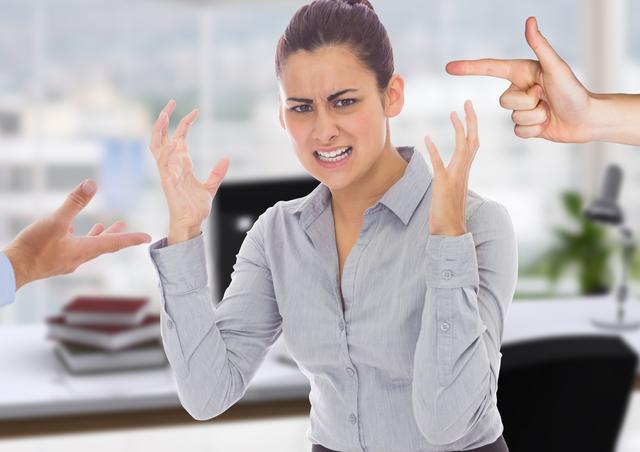 Female executive experiencing high levels of frustration and stress in a corporate office environment. Hands pointing at her symbolize workplace conflict and pressure. Useful for illustrating concepts of workplace stress, professional challenges, and emotional strain in business settings.