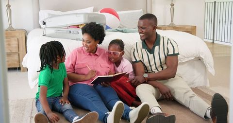 Family Enjoying Storytime and Quality Bonding on Bedroom Floor