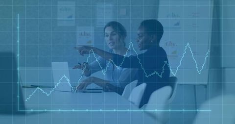 Businesswomen Analyzing Data Trends in Office with Graph Overlay