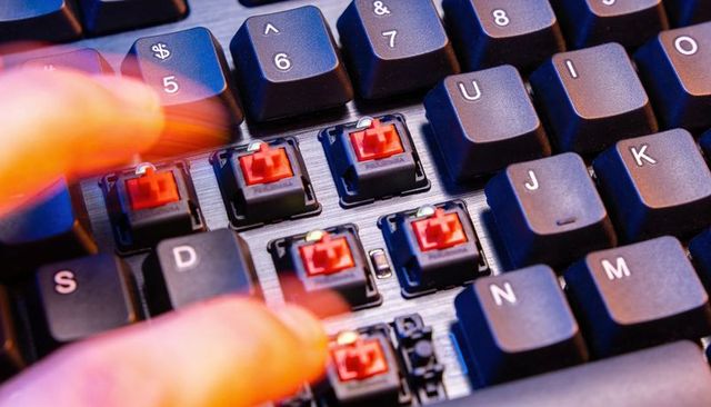 Revealing red mechanical switches with removed keycaps and blurred fingertip motion