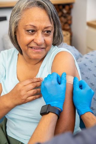 Senior african-american woman receiving home vaccination