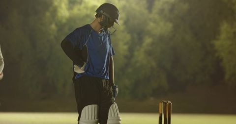 White teenage cricketer missing ball and responding to fielders appeal under lights