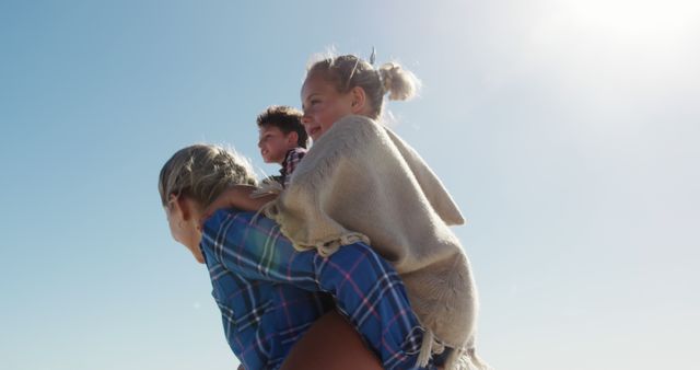 Smiling Family Piggyback Ride on Beach - Download Free Stock Images Pikwizard.com