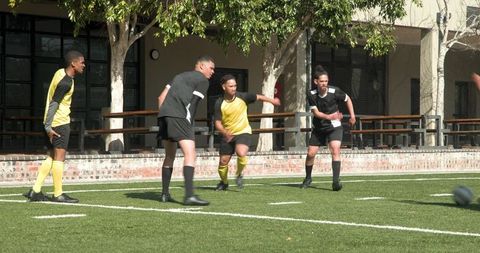 Teenagers Enhancing Soccer Skills on a Sunny School Field