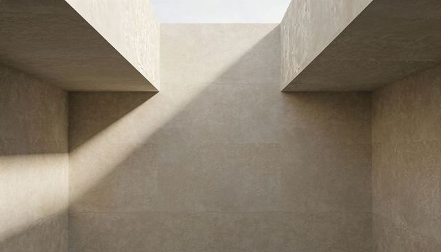 Minimalist concrete lightwell with diagonal sunlight, skylight overhangs, geometric shadow