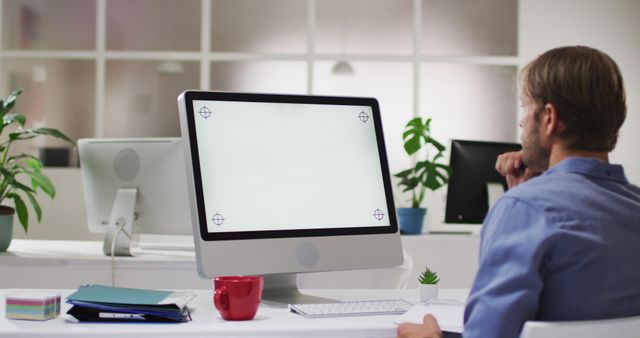 Caucasian man using computer while sitting on his desk at office. modern creative workspace designs concept