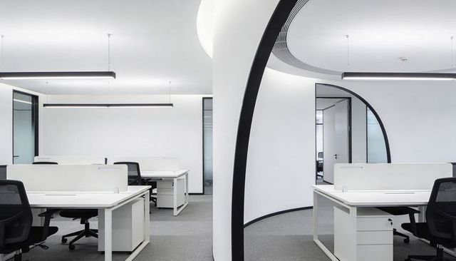 Minimalist modern open-plan office featuring curved black-trim arch partition and desks