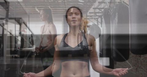 Determined Women Exercising with Jump Rope in Modern Gym