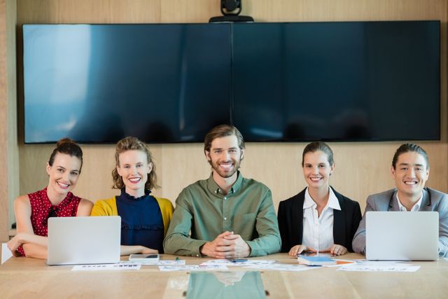 Portrait of smiling business team sitting in conference room at office