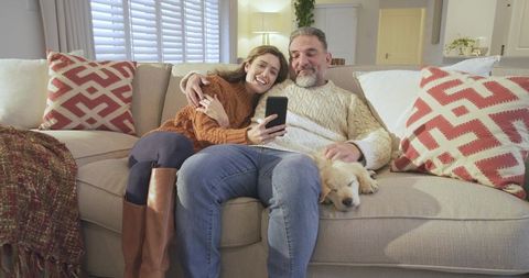 Happy Couple Enjoying Cozy Moment with Puppy at Home
