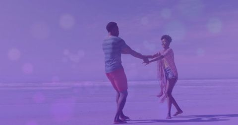 Couple enjoying beach day: dance of joy by the ocean