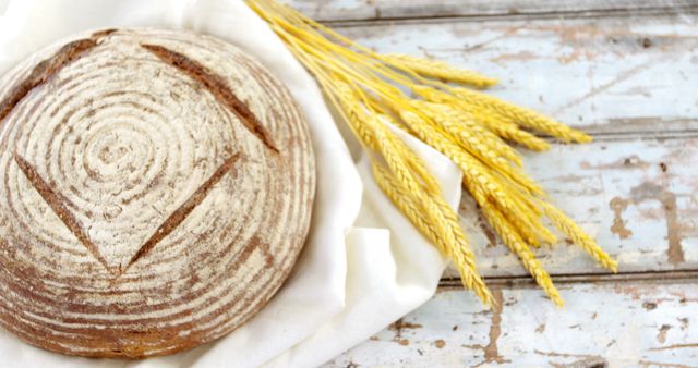 Artisanal Round Loaf of Sourdough Bread with Wheat Stalks on Rustic Table - Download Free Stock Images Pikwizard.com