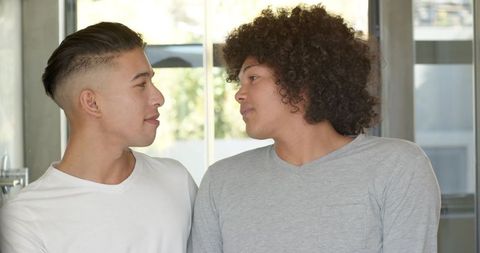 Diverse couple facing each other in modern apartment kitchen