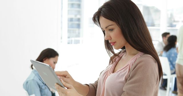 Young Woman Using Tablet Device in Modern Office - Download Free Stock Images Pikwizard.com