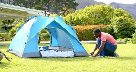 Father and Daughter Securing Tent for Backyard Camp Adventure