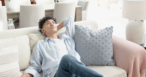 Young Man Relaxing on Sofa in Contemporary Living Room