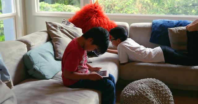 Children Relaxing on Sofa Playing with Tablets - Download Free Stock Images Pikwizard.com