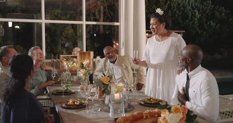 Senior Friends Celebrating at Wedding Dinner in Outdoor Setting