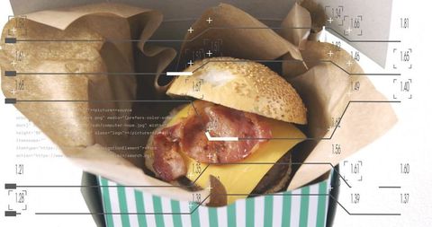Bacon cheeseburger wrapped in kraft paper showing sesame bun striped takeout box overlay graphics