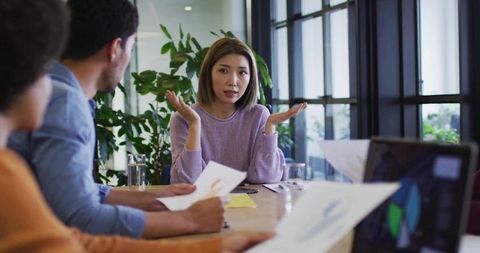 Business Meeting with Team Discussion and Chart Analysis