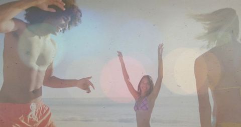 Carefree beach party friends celebrating summer in bikini and shirtless swimmer