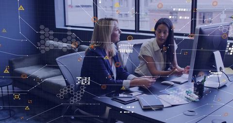 Collaborating professionals analyzing data on desktop with augmented analytics overlay