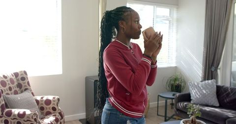 Young Woman Enjoying a Relaxing Moment with Coffee in Cozy Living Room