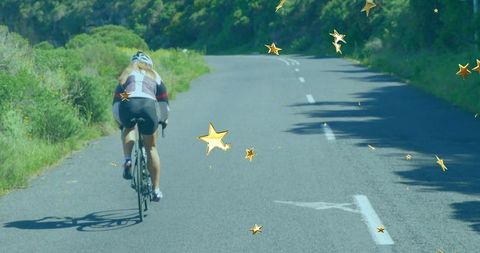 Cyclist Riding Bike on Rural Road with Vibrant Star Graphics