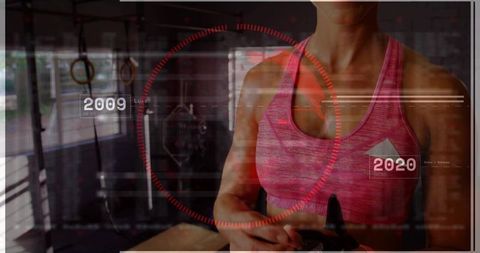 Mid-adult woman holding black shaker in gym with futuristic hud overlay for fitness studio