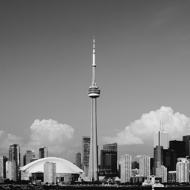 Silhouette of Toronto's skyline in black and white, featuring the iconic CN Tower and Rogers Centre. Perfect for travel brochures, city guides, architectural studies, and urban-themed projects.