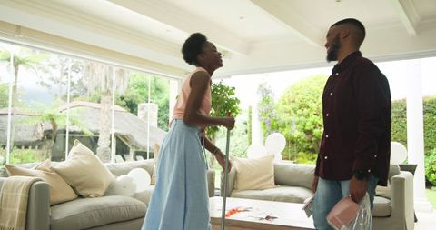 Happy Couple Collaborating on Living Room Cleanup