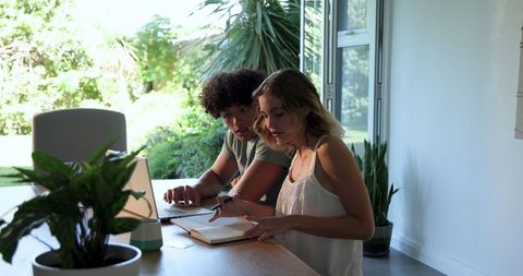 Couple Collaborating on Laptop at Eco-Friendly Home Office