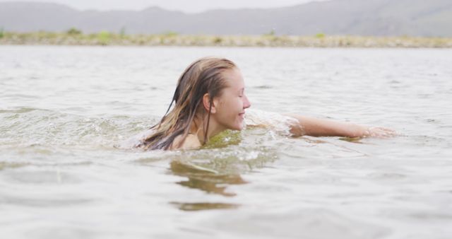 Young Woman Swimming in Lake on Cloudy Day - Download Free Stock Photos Pikwizard.com
