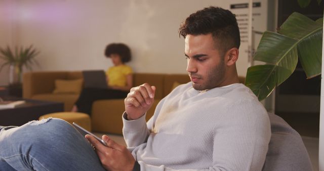 Young Man Concentrating on Tablet at Home - Download Free Stock Images Pikwizard.com