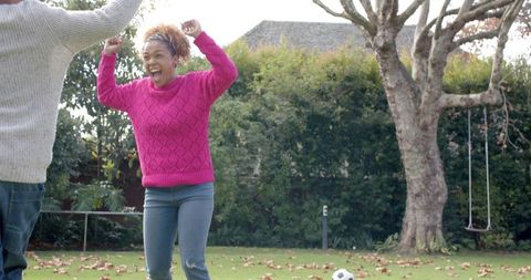 Mother and Son Celebrating After Playing Football in Garden