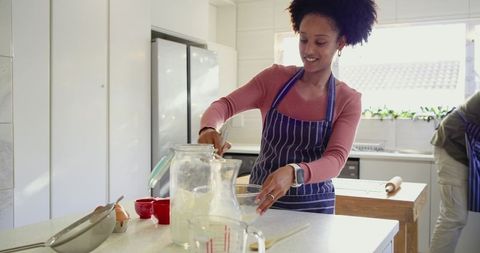 African American Couple Baking Together in Sunlit Modern Kitchen Mixing Batter Embracing Teamwork