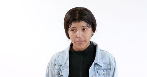 Serious young woman in denim jacket against white background