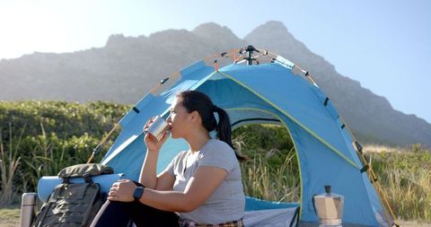 Woman Enjoying Coffee Outside Tent in Mountain Landscape